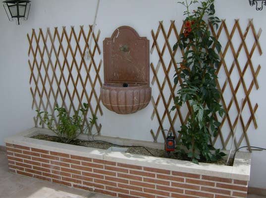Fontaine en pierre d'extérieur suspendue adossée à un mur....